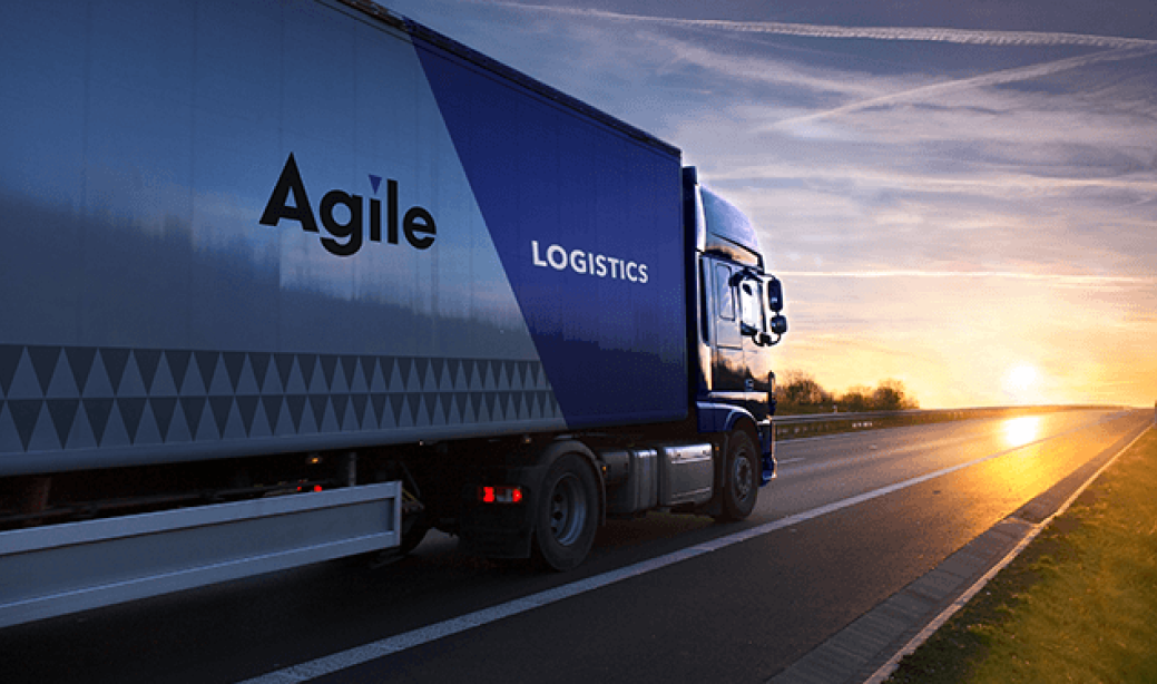 Agile Logistics - Transport Vehicle travelling across highway in the sunset