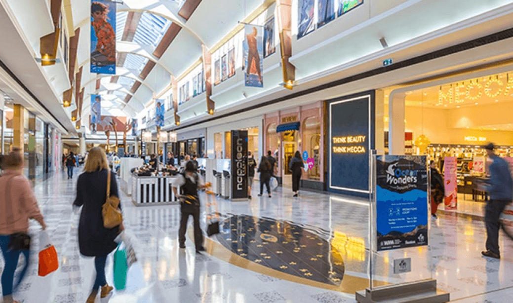 Retail stores with shoppers walking through a mall | Agile Group